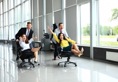 Cheerful colleagues having fun in office chairs