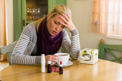 Frau im Krankenstand mit Tee und Medikamenten. Erkältung, Schnupfen und Grippezeit